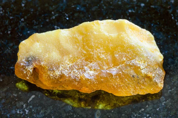 Rough baltic Amber stone on dark — Stock Photo, Image