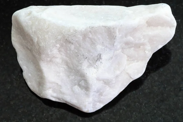 Шматок білого мармурового каменю на темному фоні — стокове фото