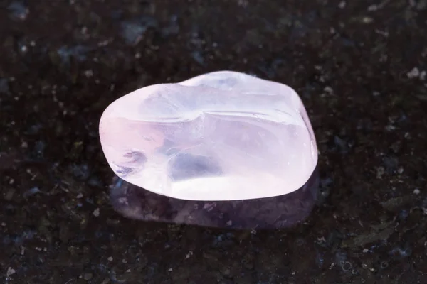 Pedra preciosa de quartzo rosa polida no fundo escuro — Fotografia de Stock