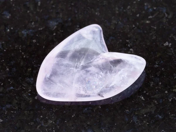 Piedra de cuarzo rosa caída en forma de corazón en la oscuridad — Foto de Stock