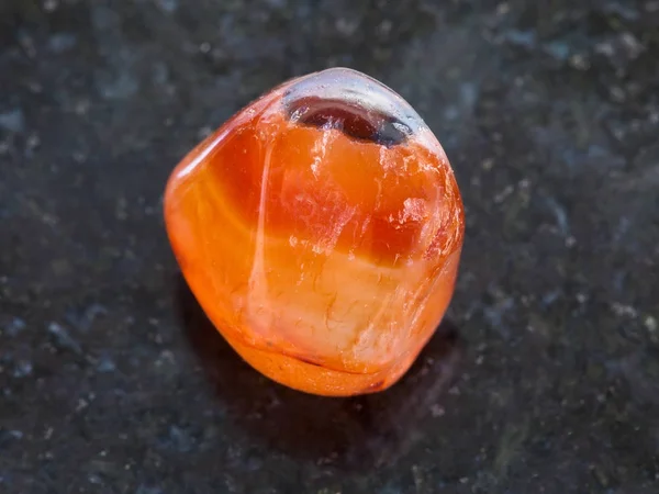 Tumbled carnelian gem stone on dark background — Stock Photo, Image