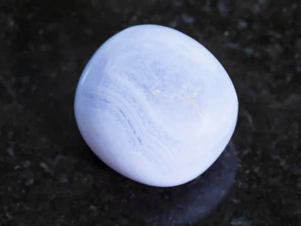 Tumbled blue chalcedony gemstone on dark — Stock Photo, Image