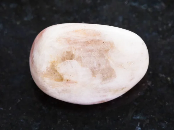 Gema de piedra lunar pulida sobre fondo oscuro — Foto de Stock