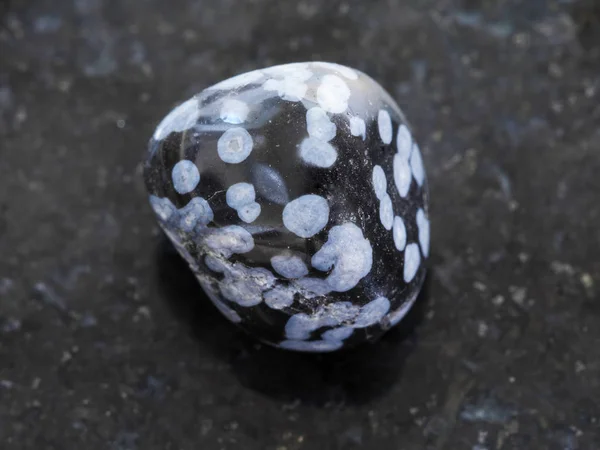 Pierre gemme d'obsidienne de flocon de neige poli sur sombre — Photo