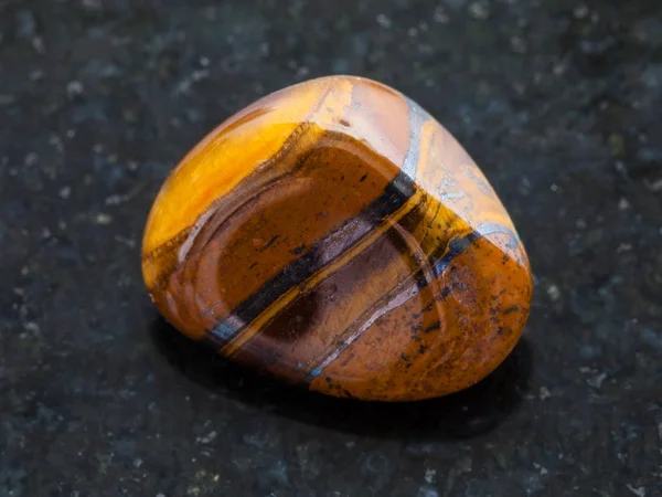 Tuimelde tigers eye edelsteen op donkere achtergrond — Stockfoto