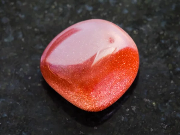 Kamień spadł czerwony goldstone na ciemny — Zdjęcie stockowe