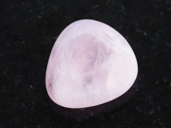 Piedra gema de cuarzo rosa pulido en la oscuridad — Foto de Stock