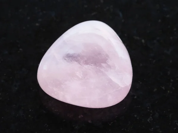 Tumlade rosa kvarts pärla sten på mörk — Stockfoto