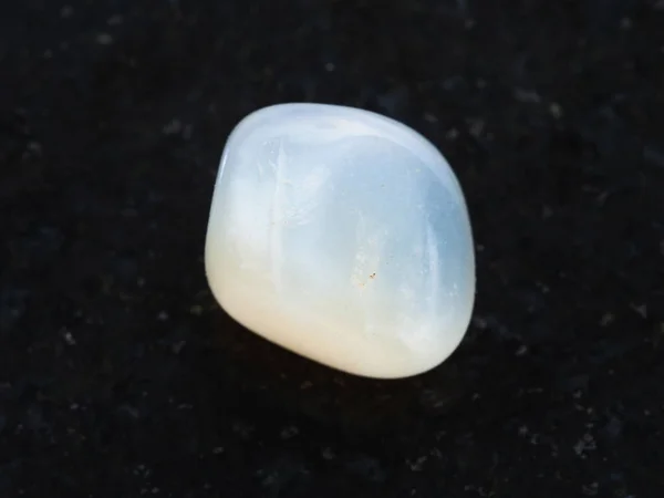 Tumbled translucent moonstone gemstone on dark — Stock Photo, Image