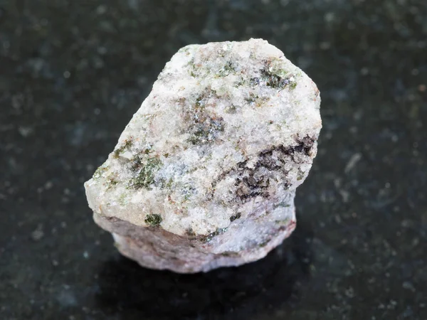 Грубий апатійський камінь на темному гранітному фоні — стокове фото