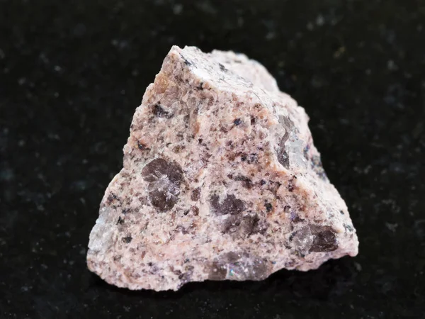 Pedra de granito cru no fundo de granito escuro — Fotografia de Stock