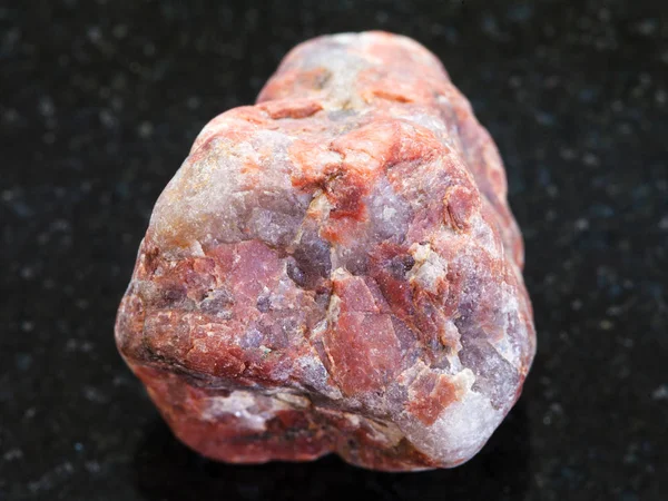 Guijarro de piedra Pegmatita sobre fondo oscuro — Foto de Stock