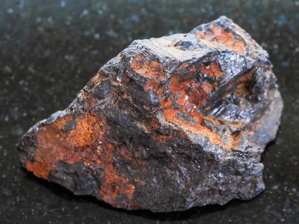 Pedra de Wolframite áspera (minério de tungstênio) no escuro — Fotografia de Stock