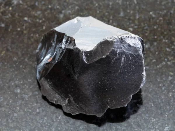 Obsidiana cruda (vidrio volcánico) cristal en la oscuridad — Foto de Stock