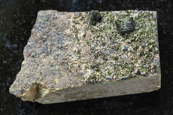 Cristales ásperos de Epidote sobre roca en oscuridad — Foto de Stock