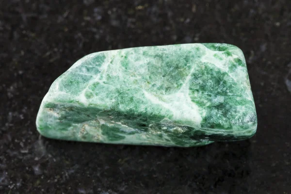 Piedra jadeíta verde pulido sobre fondo oscuro — Foto de Stock