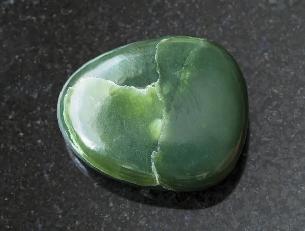 Tumbled green nephrite gemstone on dark — Stock Photo, Image