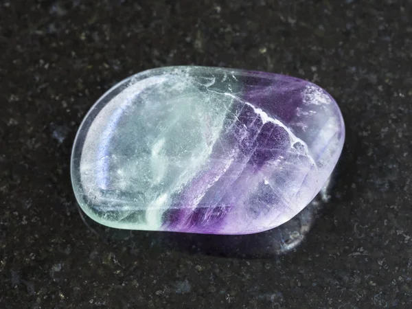 Piedra de gema de flúor tumbado sobre fondo oscuro — Foto de Stock