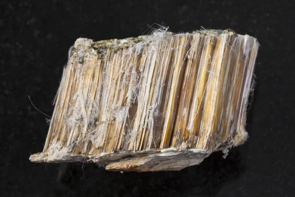 Karkea ruskea asbestikivi tummalla pohjalla — kuvapankkivalokuva