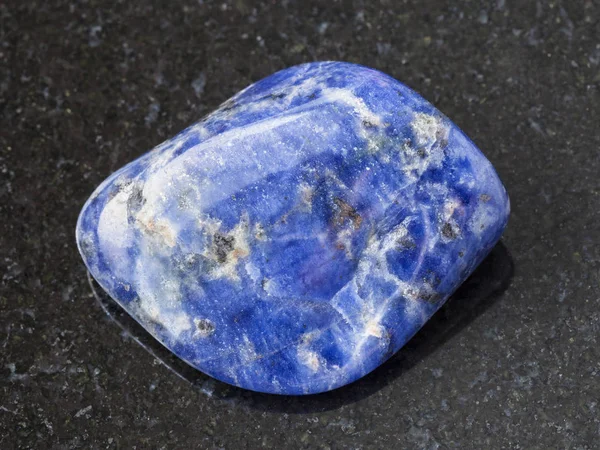 Pietra preziosa Sodalite caduto su sfondo scuro — Foto Stock