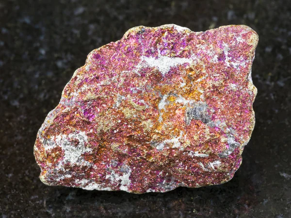 Piedra de Chalcopyrite roja rugosa sobre fondo oscuro — Foto de Stock