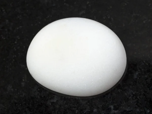 Cacholong polido (opala branca) pedra preciosa no escuro — Fotografia de Stock
