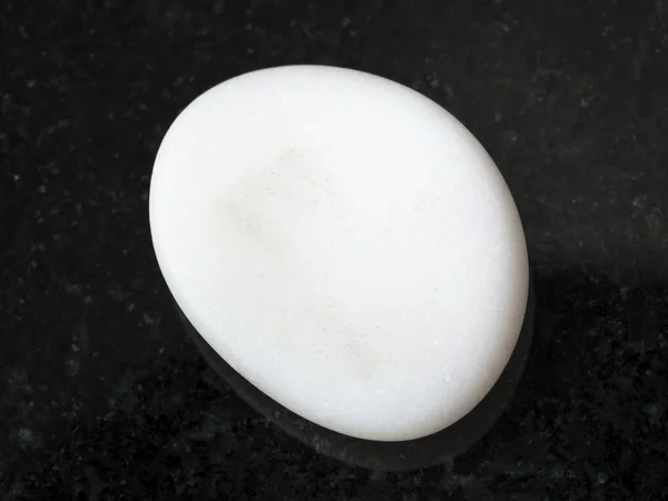 Cacholong tumbled (opale bianco) gemma sul buio — Foto Stock