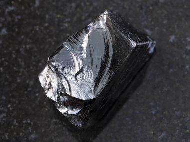 piece of raw Obsidian (volcanic glass) on dark clipart