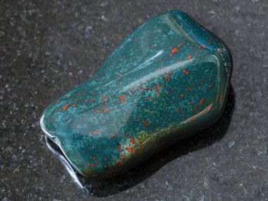 polished green Heliotrope gem stone on dark clipart