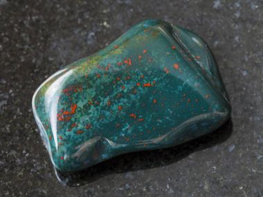tumbled green Heliotrope gem stone on dark clipart