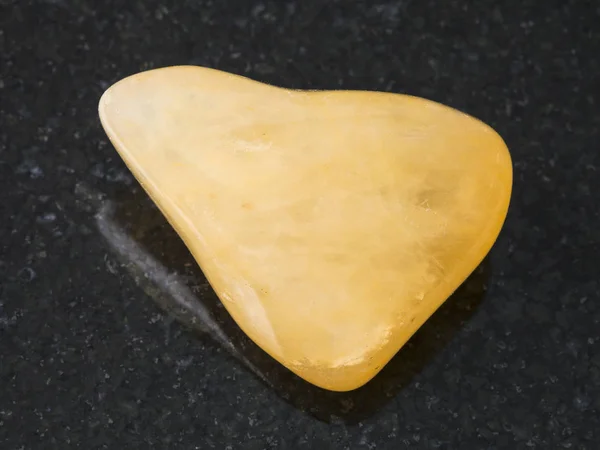 Piedra gema aventurina amarilla tumbled en la oscuridad — Foto de Stock