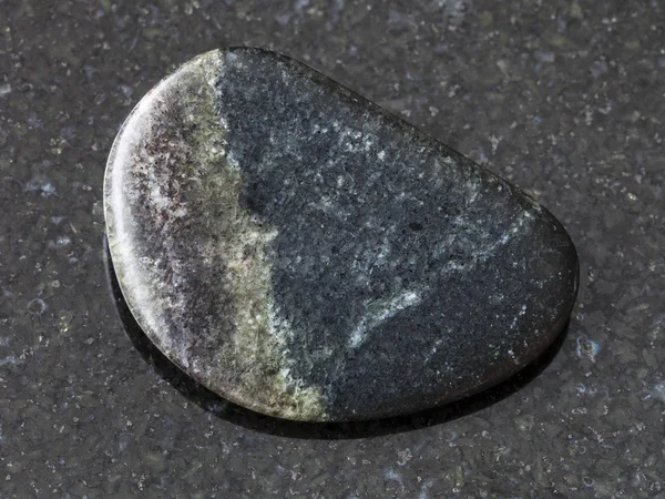 Полированный оливенитовый камень на тёмном фоне — стоковое фото