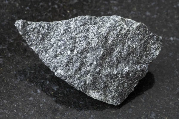 Piedra dolerita cruda sobre fondo oscuro — Foto de Stock