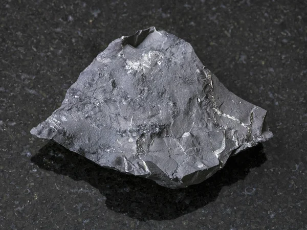 Pedra de xisto shungite cru no fundo escuro — Fotografia de Stock