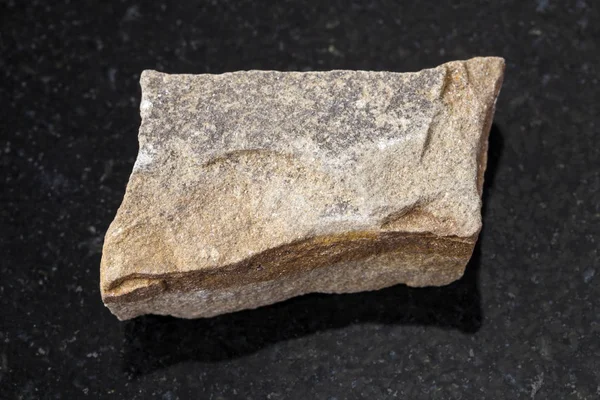 Rough polymictic sandstone stone on dark — Stock Photo, Image