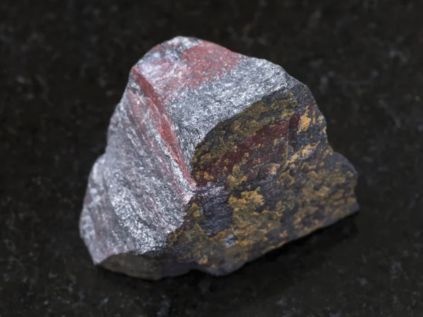 Raw jaspilite (ferruginous quartzite) on dark — Stock Photo, Image