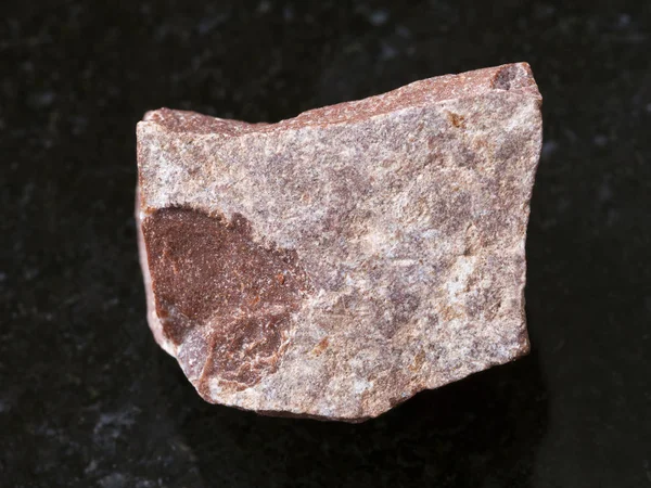 Кусок необработанного красного мраморного камня на темном — стоковое фото