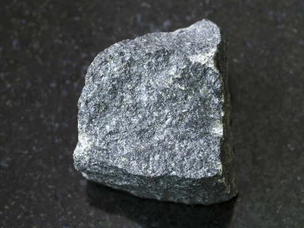 Pietra grezza di Gabbro su sfondo scuro — Foto Stock