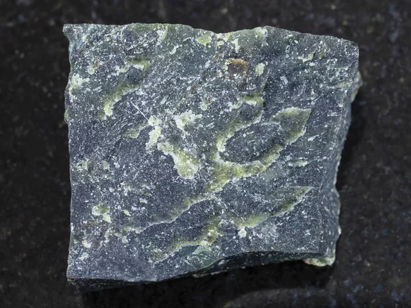Τραχύ δουνίτη πέτρα σε σκούρο φόντο — Φωτογραφία Αρχείου