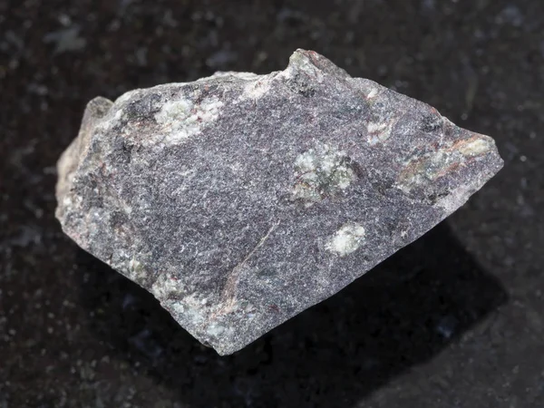 RAW γρανοδιοριτικού πορφύρη πέτρα βασάλτης σε σκούρο φόντο — Φωτογραφία Αρχείου