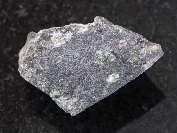 Piedra de basalto porfiritica cruda sobre fondo oscuro — Foto de Stock