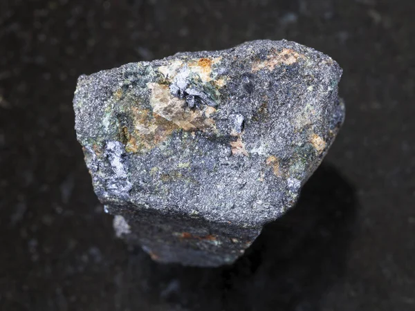 Pedra de molibdenita áspera no fundo escuro — Fotografia de Stock