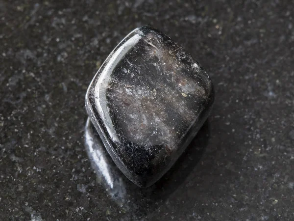 Полированный антофиллитовый драгоценный камень в темноте — стоковое фото