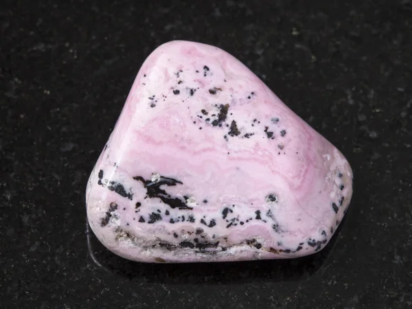 Rhodochrosite polerowany klejnot na ciemnym tle — Zdjęcie stockowe