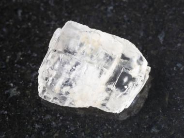 rough crystal of Petalite gemstone on dark clipart