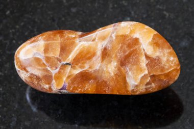 koyu arka plan üzerinde cilalı tinaksite değerli taş