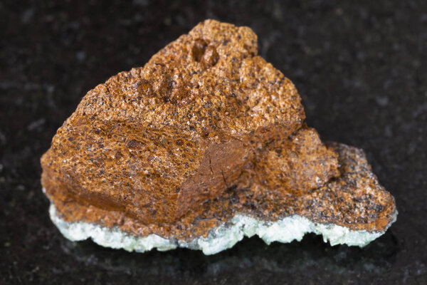 rough bog iron ore ( limonite) stone on dark