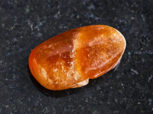 Полированный драгоценный камень Spessartine на темном — стоковое фото