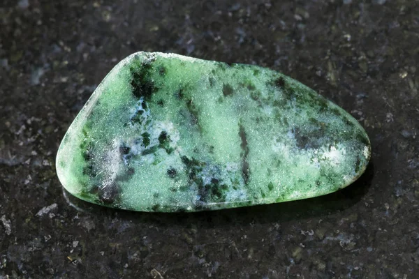 Полированный зоизитный драгоценный камень на тёмном фоне — стоковое фото