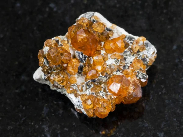 Грубые кристаллы спессартинного драгоценного камня на темной — стоковое фото